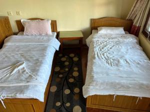 dos camas sentadas una al lado de la otra en una habitación en Astam Resort, en Astam