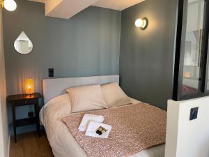 a bedroom with a bed with two pillows on it at escapade aux portes de Paris in Suresnes
