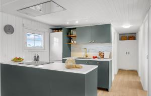 a kitchen with blue cabinets and a white counter top at 2 Bedroom Stunning Home In Harboøre in Harboør +19 photos