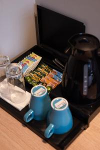 a tray with two blue cups and a tea kettle at HOTEL GRACIAN in Sremska Mitrovica