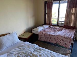 Habitación de hotel con 2 camas y ventana en Astam Resort, en Astam