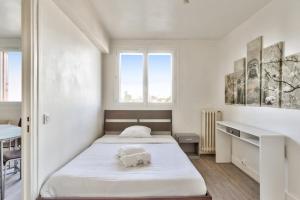 a bedroom with two beds and a window at Charming flat with balcony at the doors of Paris - Welkeys in La Courneuve