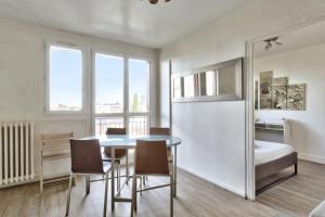 een keuken en eetkamer met een tafel en stoelen bij Charming flat with balcony at the doors of Paris - Welkeys in La Courneuve