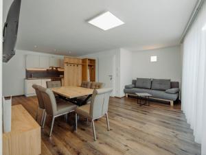 uma sala de estar com uma mesa e cadeiras e um sofá em Appartement Hammerrain em Flachau