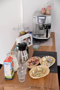 einen Tisch mit Teller mit Lebensmitteln und eine Kaffeemaschine in der Unterkunft Guest House Aan de Hollandse IJssel in Montfoort