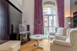 un soggiorno con divano, tavolo e TV di FULL HOUSE NEAR CATHEDRAL AND REAL MAESTRANZA by Antonia Diaz street a Siviglia