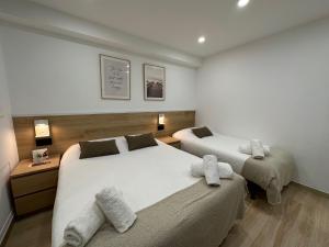 um quarto com 2 camas e toalhas em Hostal Alogar em Barcelona