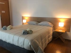 een slaapkamer met een groot bed met 2 lampen bij AZORES HOLIDAYS HOUSE -B&B - Suites - Self Check-in KEYBOARD in Ponta Delgada