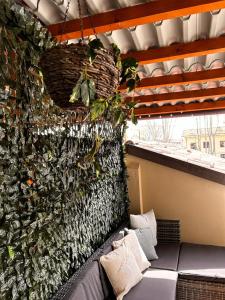a green wall with a couch in front of it at Bon Bon del Corso con terrazzo e aria condizionata in Asti