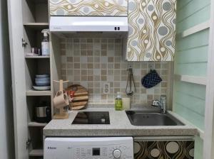 uma pequena cozinha com um lavatório e um fogão em Cozy Place near Kyeongbuk university em Daegu