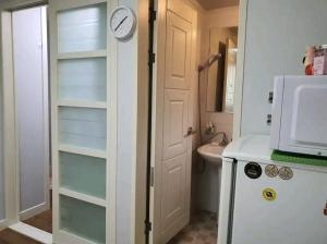 a bathroom with a sink and a clock on a door at Cozy Place near Kyeongbuk university in Daegu