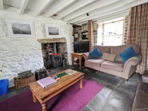 a living room with a couch and a fireplace at Millers Cottage, Broughton - family & pet friendly in Broughton in Furness