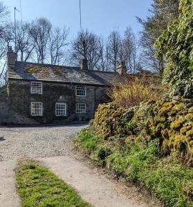 an old stone house with a gravel road in front of it at Millers Cottage, Broughton - family & pet friendly in Broughton in Furness