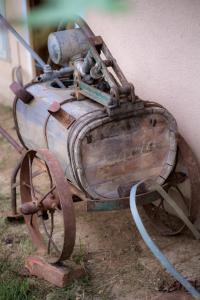 an old metal machine sitting next to a building at Tourist Farm Firbas in Cerkvenjak