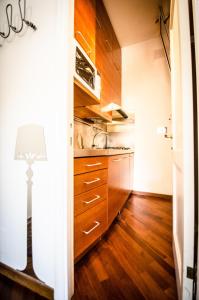 uma cozinha com armários de madeira e um candeeiro em Scent Of Trastevere em Roma