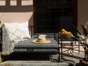 un sombrero sentado en un banco en un patio en Sweet Orange Guest House, en Ciudad del Cabo
