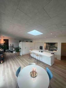 Nyt hus fra 2022 med jungle vibe في Nørresundby: غرفة مع طاولة وكراسي ومطبخ