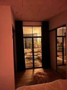 a room with a bed and a view of a patio at Nyt hus fra 2022 med jungle vibe in Nørresundby
