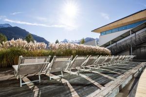 une rangée de chaises assises à l'extérieur d'un bâtiment dans l'établissement Tauern Spa Hotel & Therme, à Kaprun