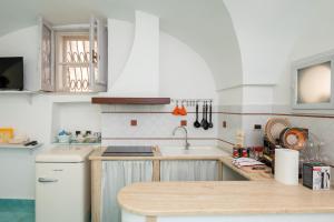 uma cozinha com armários brancos e um balcão de madeira em Divina Casa Vacanze em Sperlonga