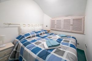 Un dormitorio con una cama azul y blanca con toallas. en Divina Casa Vacanze en Sperlonga