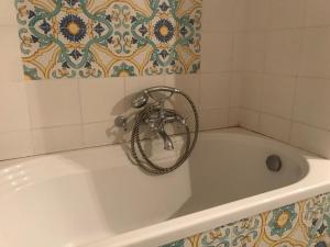 eine weiße Badewanne mit einem Wasserhahn im Bad in der Unterkunft Casa Amedeo in Neapel
