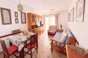a living room with a table and chairs and a television at Vera Mar 8A Primera linea con Piscina y Parking in Arona