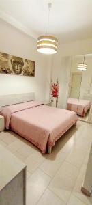 um quarto com uma grande cama rosa num quarto em Il gingillo di Alice em Letojanni