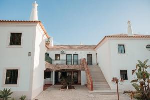 an exterior view of a white house with stairs at Casa Velha Apartments - Adults friendly in Albufeira