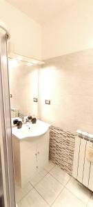 uma casa de banho branca com um lavatório e um espelho em Il gingillo di Alice em Letojanni