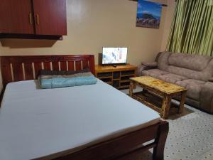 a bedroom with a bed and a couch and a table at Ella's Haven in Nairobi