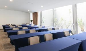 una sala de conferencias con mesas y sillas azules en Hotel Viaggio 617, en Bogotá