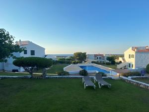 a view of a yard with two chairs and a swimming pool at La Casa del Jardin. Menorca in Punta Grossa
