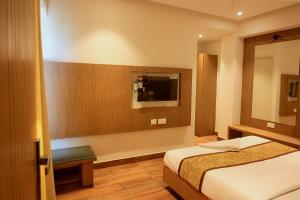 pokój hotelowy z łóżkiem i telewizorem w obiekcie GRAND ONE TOWER w mieście Ćennaj