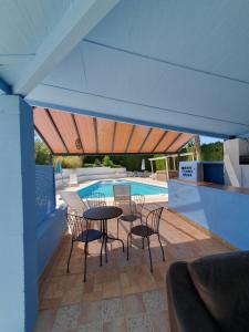 a patio with a table and chairs next to a swimming pool at Casa Olivar B&B in Tocon