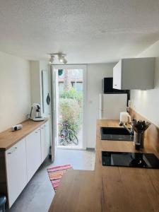 a kitchen with white cabinets and a wooden counter top at La maison du Clos in Valras-Plage