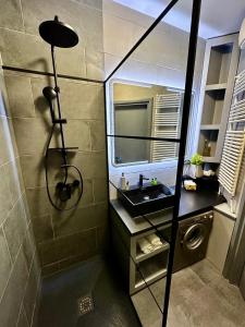 bagno con doccia e lavandino di Leda Apartments a Budapest