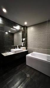ein großes Badezimmer mit zwei Waschbecken und einer Badewanne in der Unterkunft Marmenio Hotel - Tbilisi in Tbilisi City