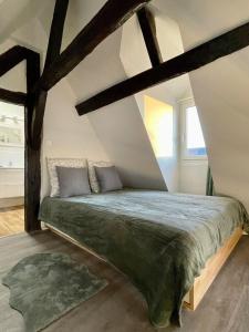 a bedroom with a large bed in a attic at Le 1731, Rouen coeur d'histoire, superbe duplex in Rouen