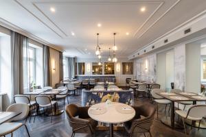 a restaurant with tables and chairs and windows at Hotel City Central in Vienna