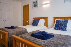 Duas camas num quarto com toalhas azuis em Beyond The Sea - FREE all Island parking permit em Ventnor