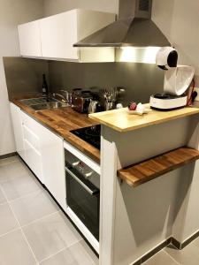 uma cozinha com armários brancos e um forno com placa de fogão em La Loge d'Harcourt : Hypercentre chic et moderne em Rouen