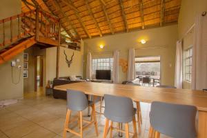 - un salon avec une grande table et des chaises en bois dans l'établissement Kudus Crest Bush Retreat, à Marloth Park