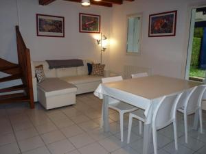 een woonkamer met een tafel en stoelen en een bank bij Maison mitoyenne jardin piscine tennis in Hendaye