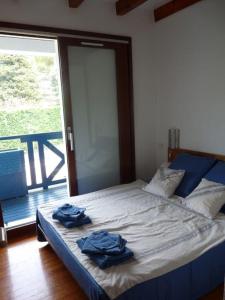 una camera da letto con un letto con due asciugamani blu sopra di Maison mitoyenne jardin piscine tennis a Hendaye