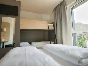 a bedroom with two bunk beds and a window at B&B Hotel Köln-City in Cologne