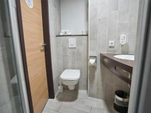 ein kleines Bad mit WC und Waschbecken in der Unterkunft B&B Hotel Köln-City in Köln