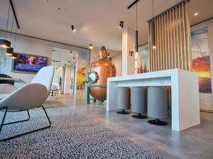 ein Zimmer mit einem Tisch und Stühlen sowie einer großen Vase in der Unterkunft B&B Hotel Köln-City in Köln
