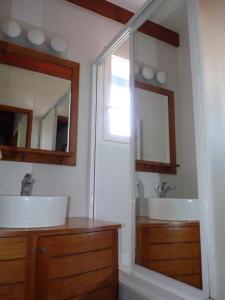 a bathroom with two sinks and a large mirror at Maison mitoyenne jardin piscine tennis in Hendaye