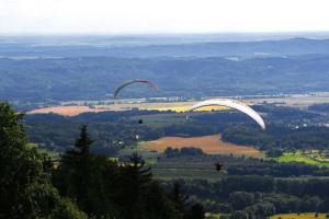 dos parapentes volando en el aire sobre un campo en Stylový vesnický apartmán v soukromí M. Skála Český Ráj, en Koberovy